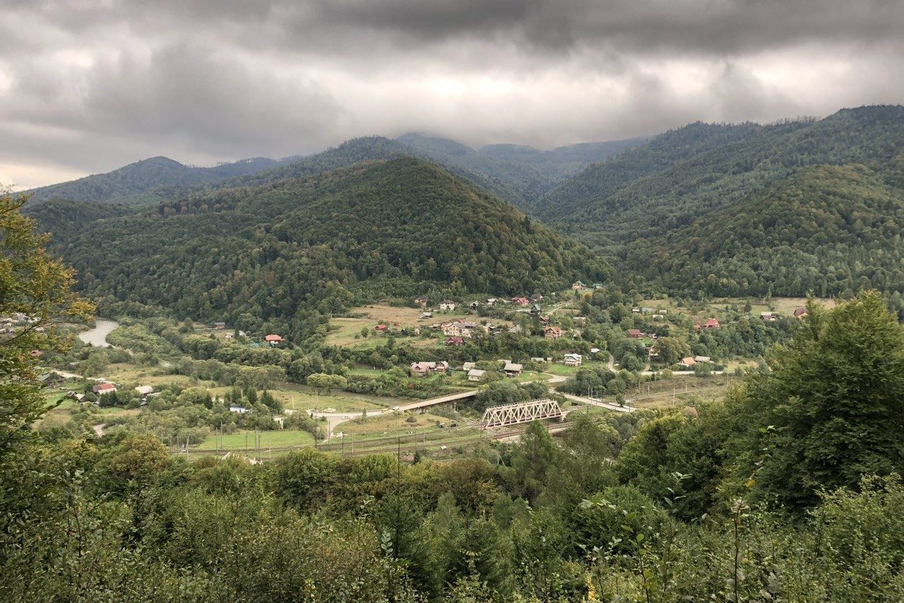 Долина Опору під хмарами, довкола залісені гори